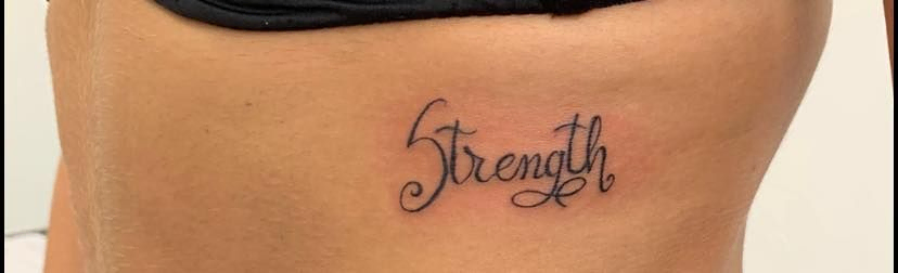 palabra Strength tatuada en la espalda