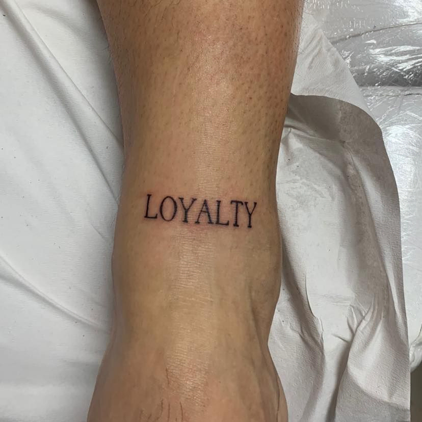 tatuaje de línea fina con la palabra "Loyalty"