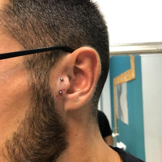 persona con piercing doble en la oreja