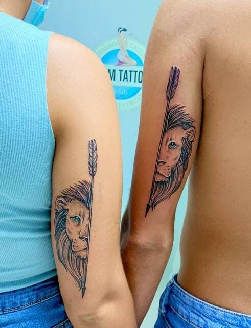 dos brazos tatuados con mitades de la cara de un león